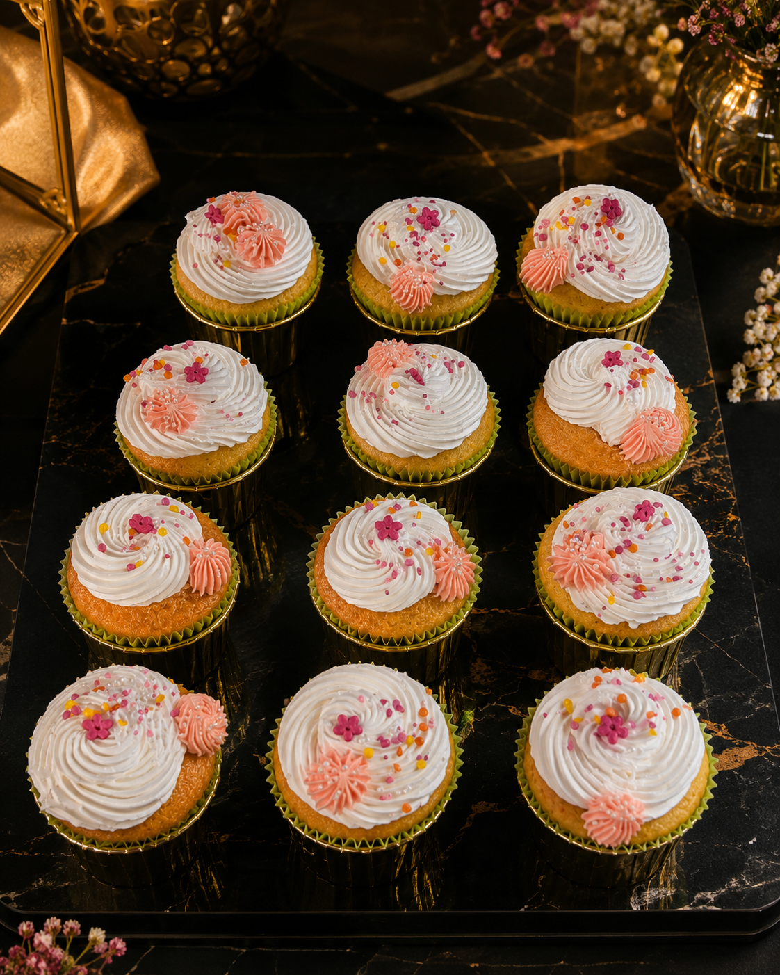 A dozen blossom cupcakes on a marble board