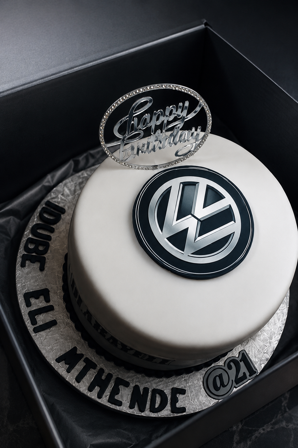 A fondant twenty first birthday cake with a car emblem